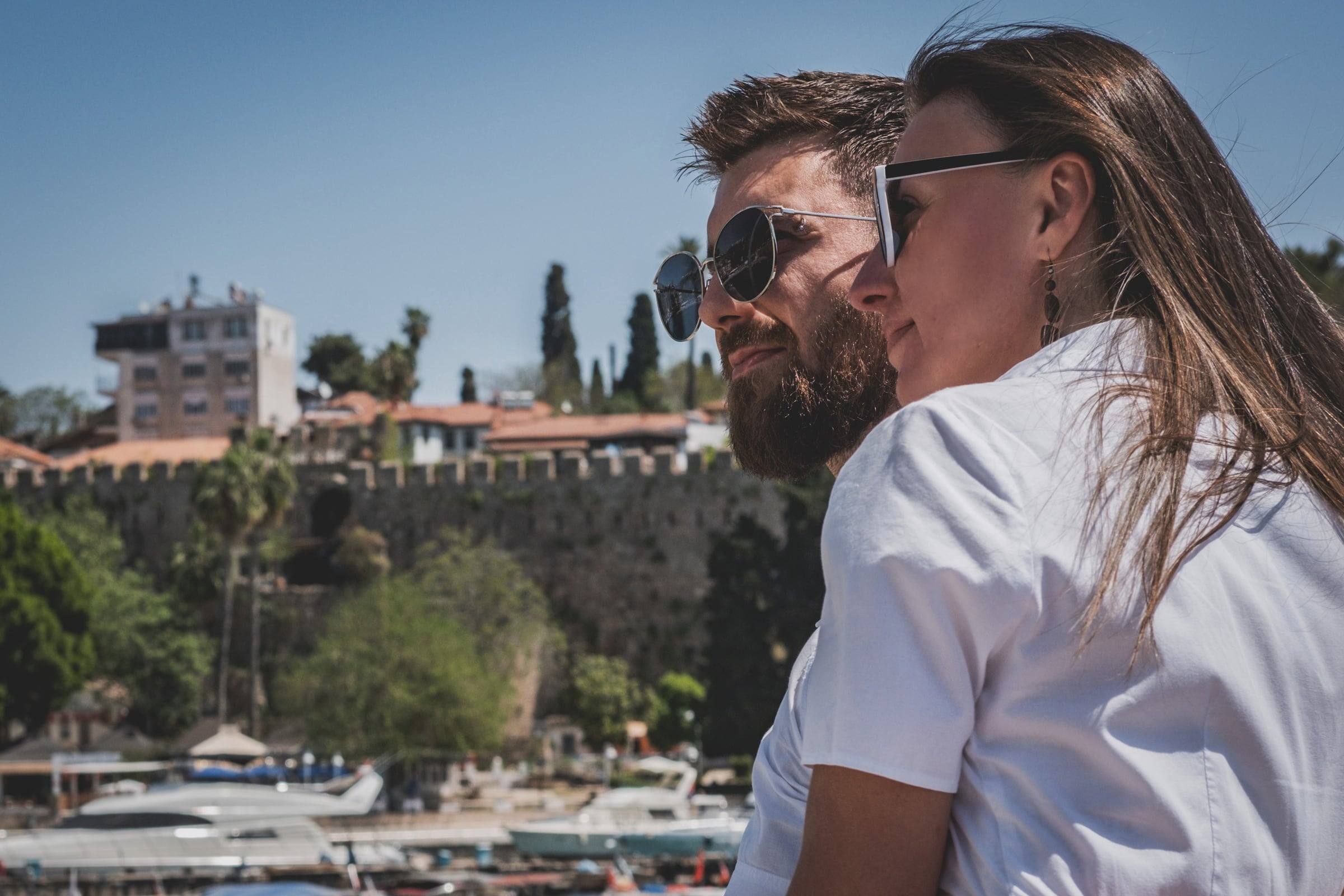 Couple in sunglasses smiling above Kaleiçi harbour
