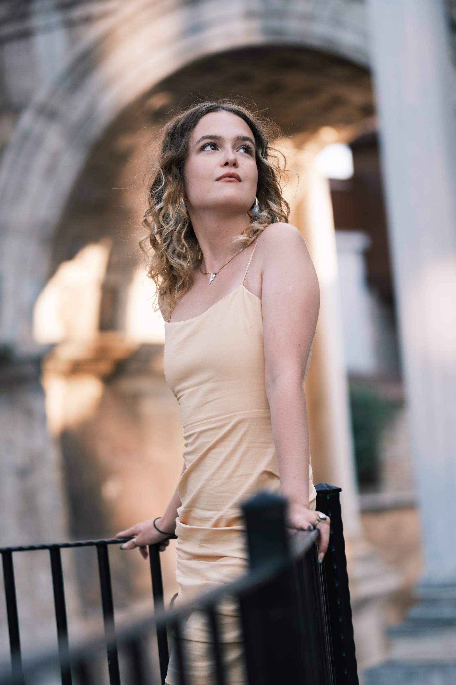 Young woman in a beige dress by the marble columns of Hadrian's Gate