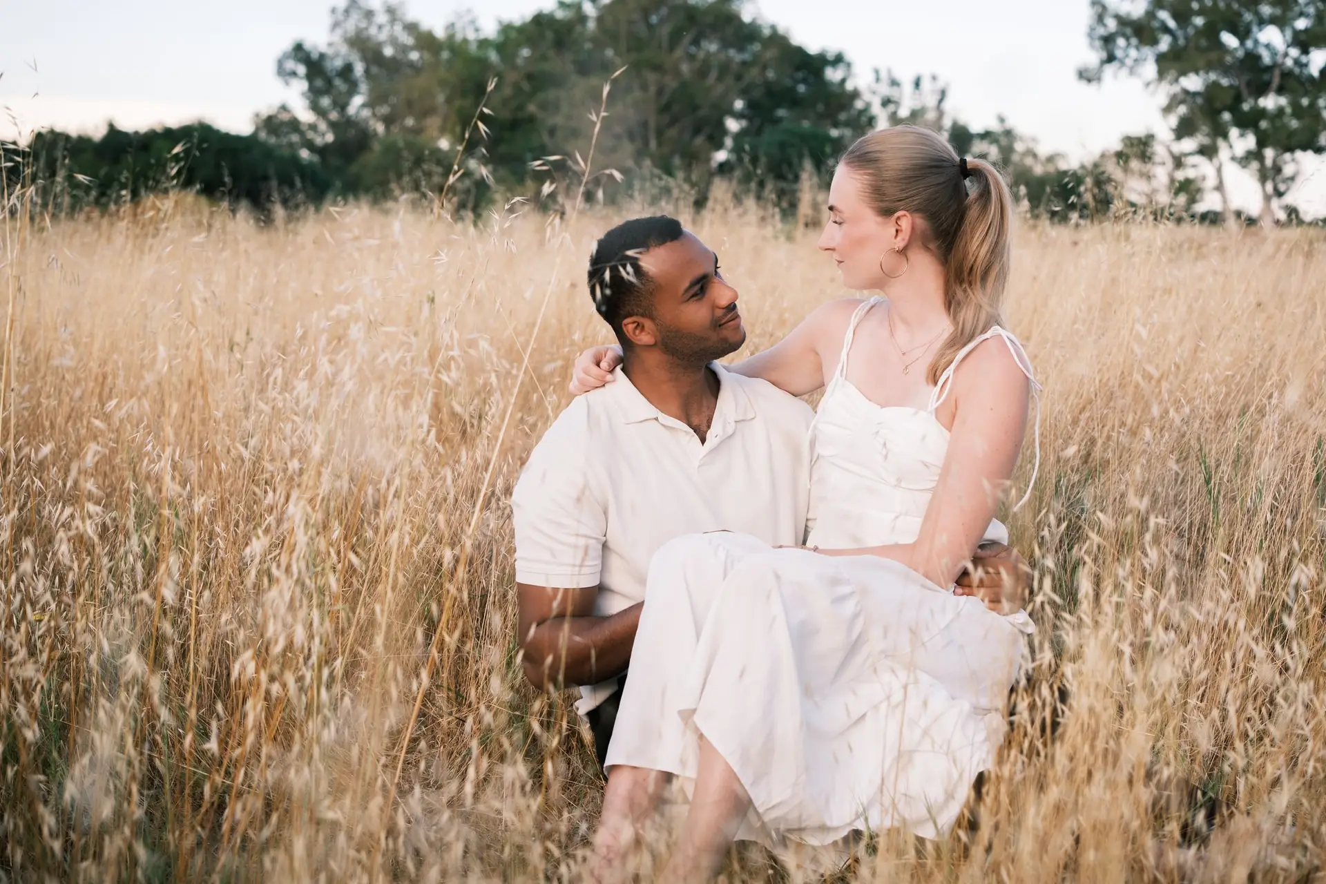 Couple sitting together in a golden summer field