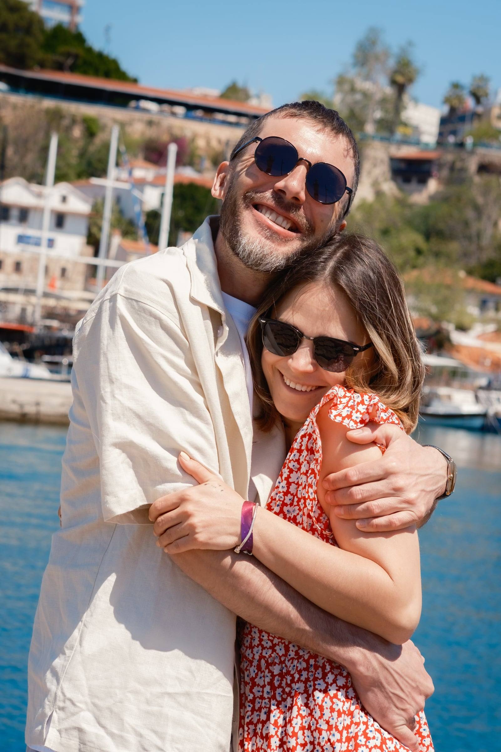 Couple hugging by the harbour on a sunny day