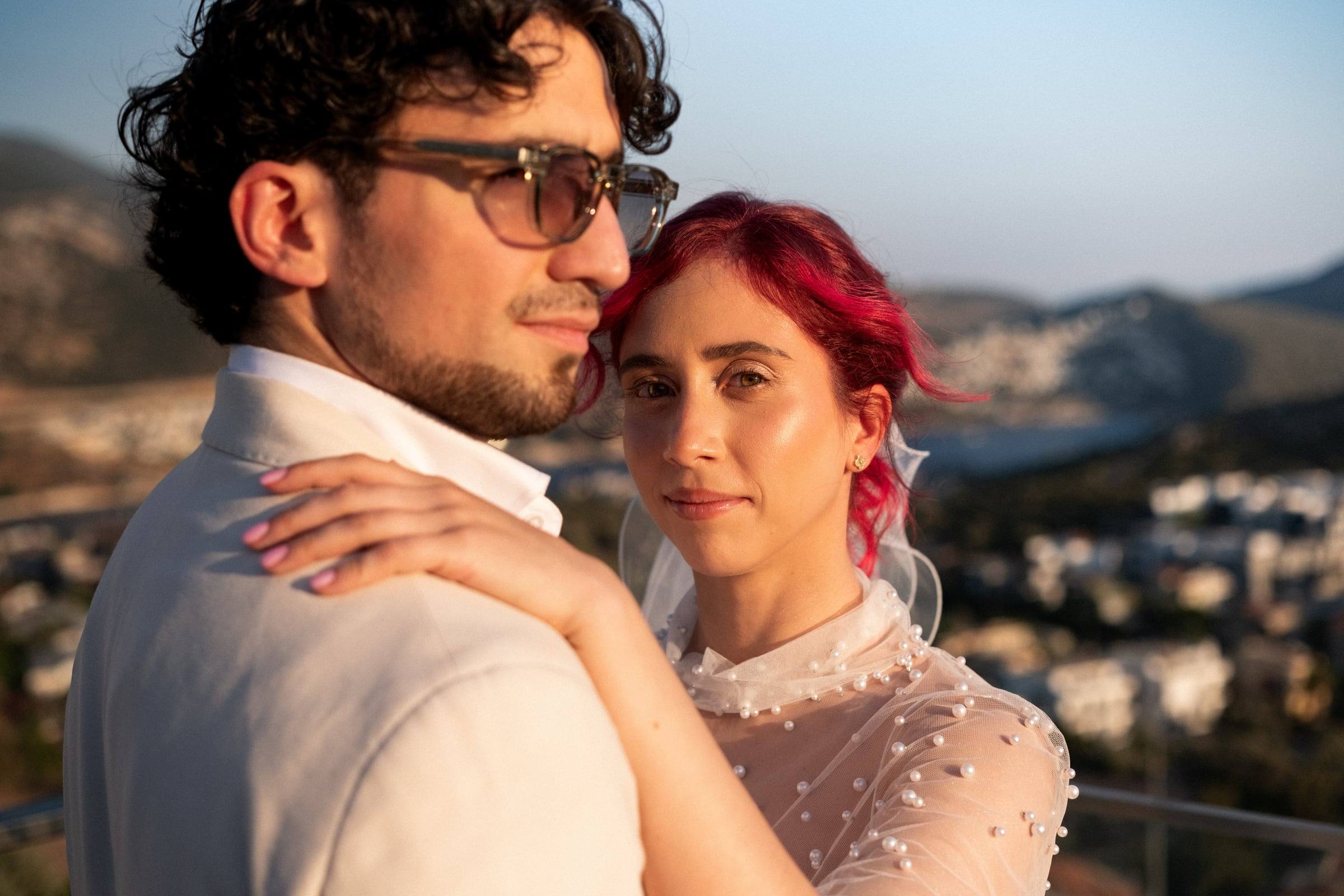 Bride with red hair and her groom above the city